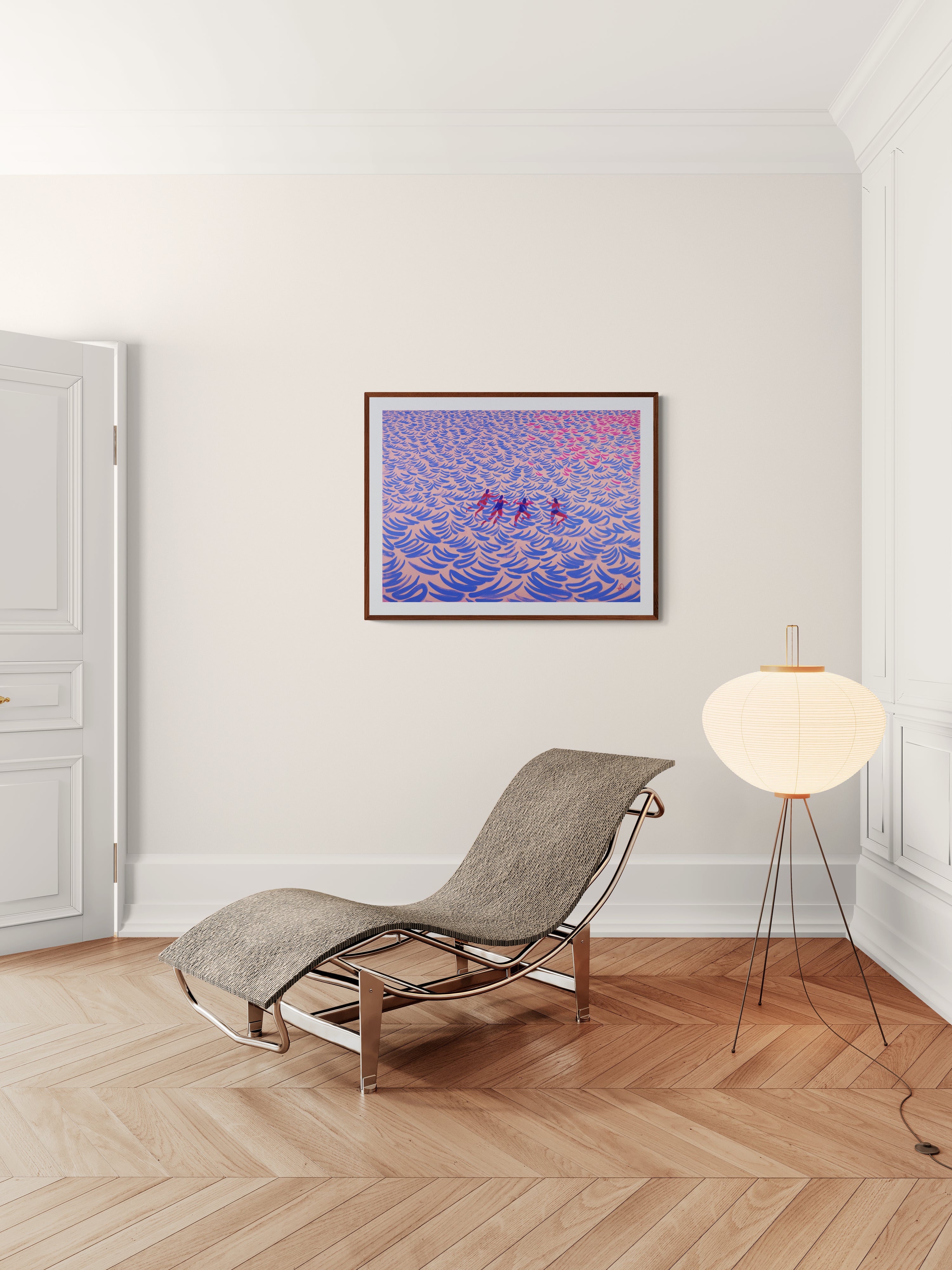 A framed limited edition print featuring people swimming in ocean, displayed on a light beige wall in a modern room setting 